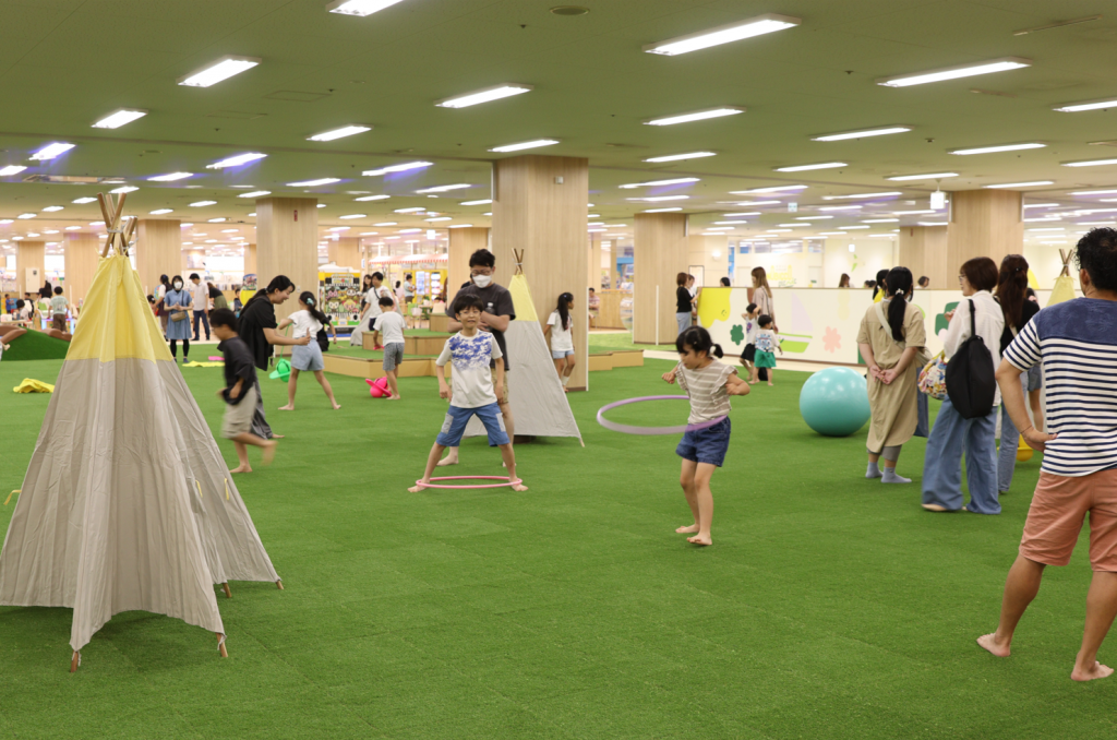 のびっこピクニック 春日井店 芝生エリアで遊ぶファミリーの写真